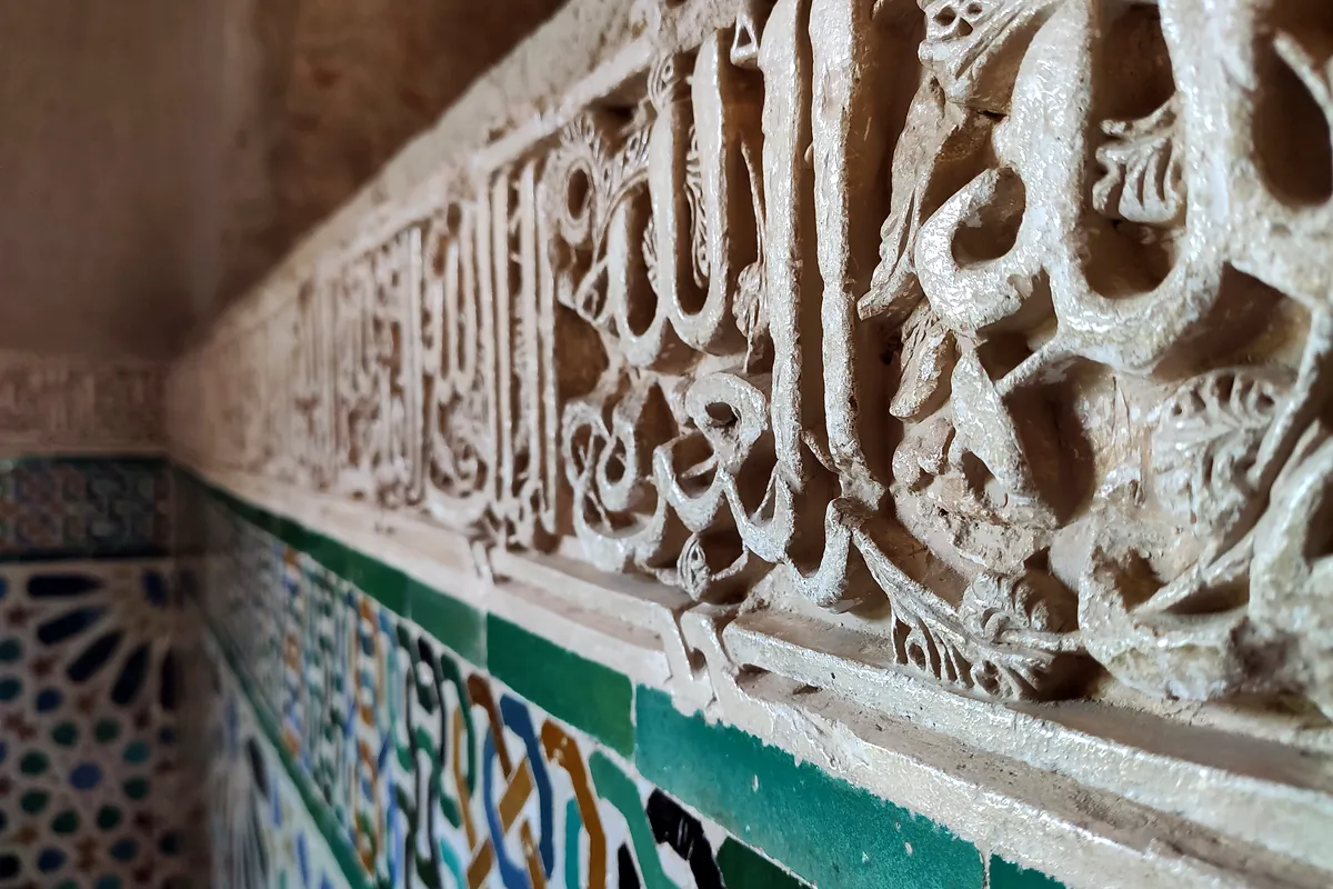 Arabic inscriptions carved into the plasterwork of the Alhambra