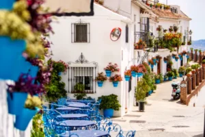 A street of whitewashed houses and blue flowerpots in Mijas