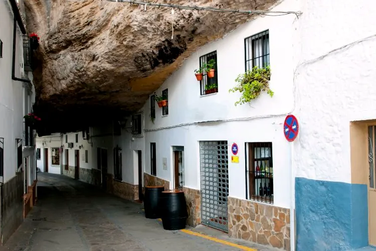 A street in Setenil de las Bodegas with white houses built under the rock