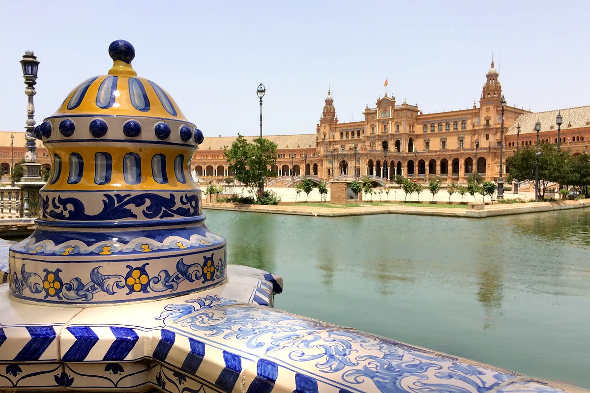 A tiled balustrade with the Plaza de España and its canal behind, in Seville